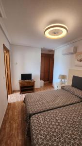 Habitación de hotel con 2 camas y escritorio con TV. en La Manga del Mar Menor Los Miradores block 1 5th floor G, en Murcia