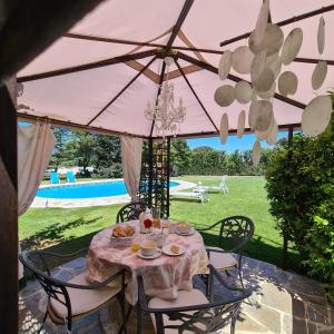 een tafel en stoelen onder een roze paraplu bij Casa Prana in Avila