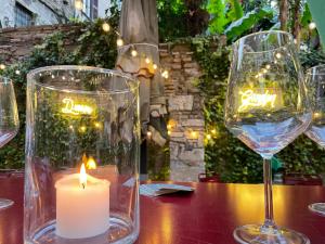 a candle and two wine glasses on a table at Passpartout Boutique Palace in Rome