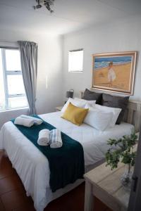 a bedroom with a large bed with towels on it at Macs Cove, Marina Martinique in Jeffreys Bay
