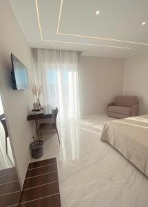 Dormitorio con cama, escritorio y TV en Meligrana Central Rooms en Tropea