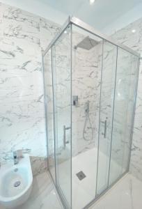 y baño con ducha de cristal y aseo. en Meligrana Central Rooms en Tropea