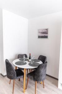- une table avec 4 chaises et une bouteille de vin dans l'établissement Apartman Krželj B3, à Livno