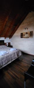 sypialnia z łóżkiem i drewnianym sufitem w obiekcie Valle Florido 1 w mieście Trevelín