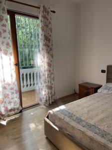 a bedroom with a bed and a large window at Ajla’s home in Vorë