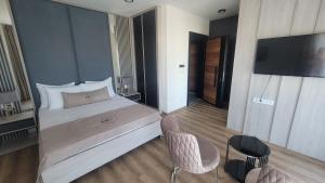 une chambre d'hôtel avec un lit et une télévision dans l'établissement Dulamerovic Hotel, à Ulcinj