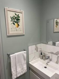 a white bathroom with a sink and a mirror at The Claremont, Seaford, South Downs, Seaside Town in Seaford