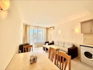 uma cozinha e sala de estar com uma mesa e um sofá em Blue Marine - Menada Apartments em Sunny Beach