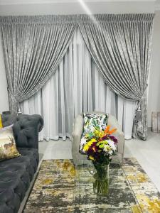 a living room with a couch and a vase of flowers at KK'S Haven in Johannesburg