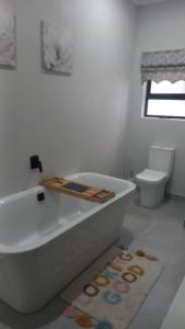 a white bathroom with a tub and a toilet at KK'S Haven in Johannesburg