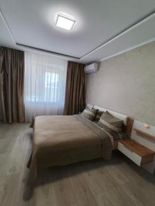 1 dormitorio con 1 cama grande en una habitación en Zlata De Luxe en Ivano-Frankivsk