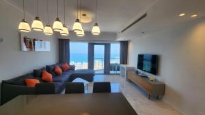 een woonkamer met een blauwe bank en een televisie bij Modern 2BR Amazing Sea View W/Parking by HolyGuest in Tel Aviv