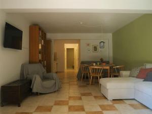 a living room with a couch and a table at Green Cozy Nest in Paleo Tsifliki