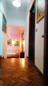 een kamer met een hardhouten vloer en een slaapkamer bij La casa di nonna Mary in Diano Castello
