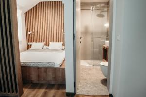a bedroom with a bed and a shower and a toilet at Apartments Triglav in Mojstrana