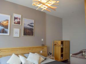 a bedroom with a bed and a chandelier at La Maison de Jeanne in Capvern