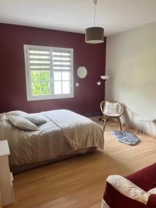 um quarto com uma cama, uma janela e uma cadeira em La rocaille 3 chambres doubles em Fondettes