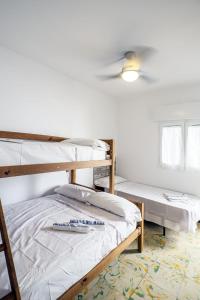 1 dormitorio con 2 literas y ventilador de techo en L'Hostalet GuestHouse, en Pineda de Mar