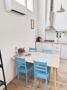 a kitchen with a wooden table and blue chairs at FABRIQ apartment in Alicante