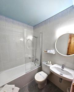 a bathroom with a toilet and a sink and a shower at Hotel Anglada in Vielha