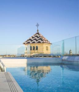 a swimming pool with a building in the background at Hotel Palacio De Úbeda 5 G.L in Úbeda