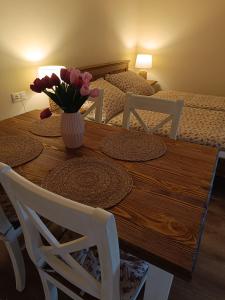 a dining room table with a vase of flowers on it at Penzión Thamasy in Spišské Tomášovce