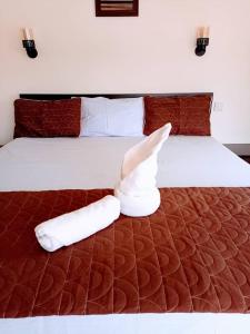 a bed with two towelsrendered to look like a bird at Akkwa 2 Suites in Kololi