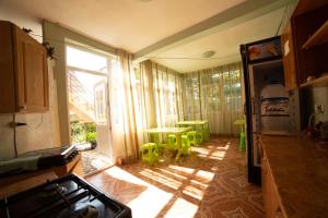 a kitchen with a table and chairs and a window at Guest House Rimma in Ureki