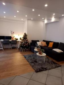 a living room with a christmas tree and a couch at Superbe appartement moderne en rez-de-chaussée in Ozoir-la-Ferrière