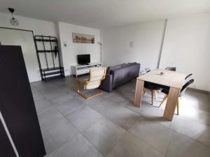 a living room with a table and a couch at Appartement Noisiel 77 (proche Disneyland & Paris) in Noisiel