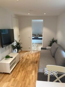 a living room with a couch and a flat screen tv at Nice guest house in Stockholm