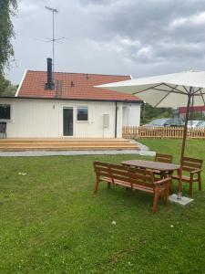 a picnic table and an umbrella in a yard at Nice guest house in Stockholm