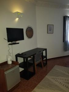ein Wohnzimmer mit einem Schreibtisch und einem TV in der Unterkunft Chez Fatima et Hervé in Somone