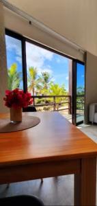 a table with a vase of flowers on top of it at Agapanthus Apartamentos in Jericoacoara