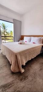 a bedroom with a large bed with a blanket on it at Agapanthus Apartamentos in Jericoacoara