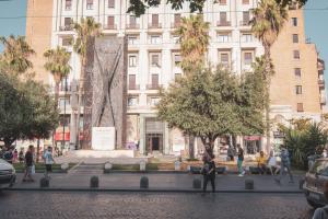 um grupo de pessoas andando em frente a um edifício em [Centro Storico] Luxury Suites em Nápoles