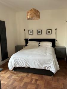 a bedroom with a large white bed with two night stands at Brannel Cottage in St Austell