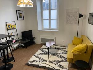 a living room with a yellow couch and a rug at *Le Yellow -Appartement T2, hypercentre* in Limoges