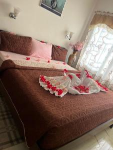 a bedroom with a bed with two dresses on it at Akkwa 2 Suites in Kololi