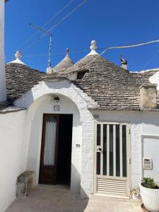 biały budynek z drzwiami i dachem w obiekcie A Due Passi dal Centro - Trullo w Alberobello