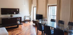 salon ze szklanym stołem i krzesłami w obiekcie Appartamento Sweet Verona w Weronie