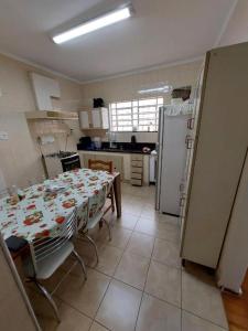 uma cozinha com uma mesa e um frigorífico em Hospedagem Franzoi em São Paulo