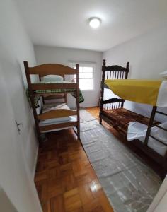 een kamer met 2 stapelbedden en een houten vloer bij Hospedagem Franzoi in Sao Paulo