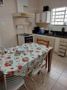 uma cozinha com uma mesa com uma toalha de mesa florida em Hospedagem Franzoi em São Paulo