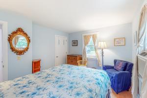 een slaapkamer met een blauw bed en een blauwe stoel bij Sea Gem Hideaway in South Dennis