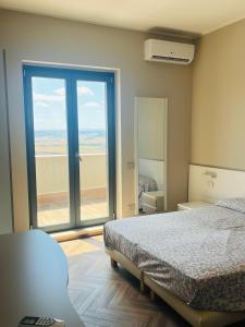 1 dormitorio con 1 cama y puerta de cristal grande en Il primo sasso, en Matera