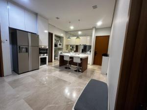 a large kitchen with a refrigerator and a counter at Soho Suites KLCC Kuala Lumpur in Kuala Lumpur