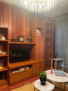 ein Wohnzimmer mit einem TV und einem Kronleuchter in der Unterkunft Casa da Poza in Redondela