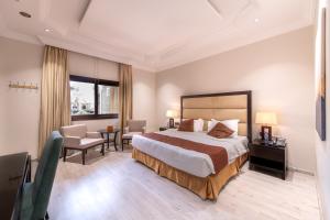 a hotel room with a bed and a table and chairs at Meral Oasis Resort Taif in Taif