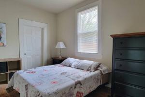 a bedroom with a bed and a dresser and a window at NOLA Hideaway RS in New Orleans